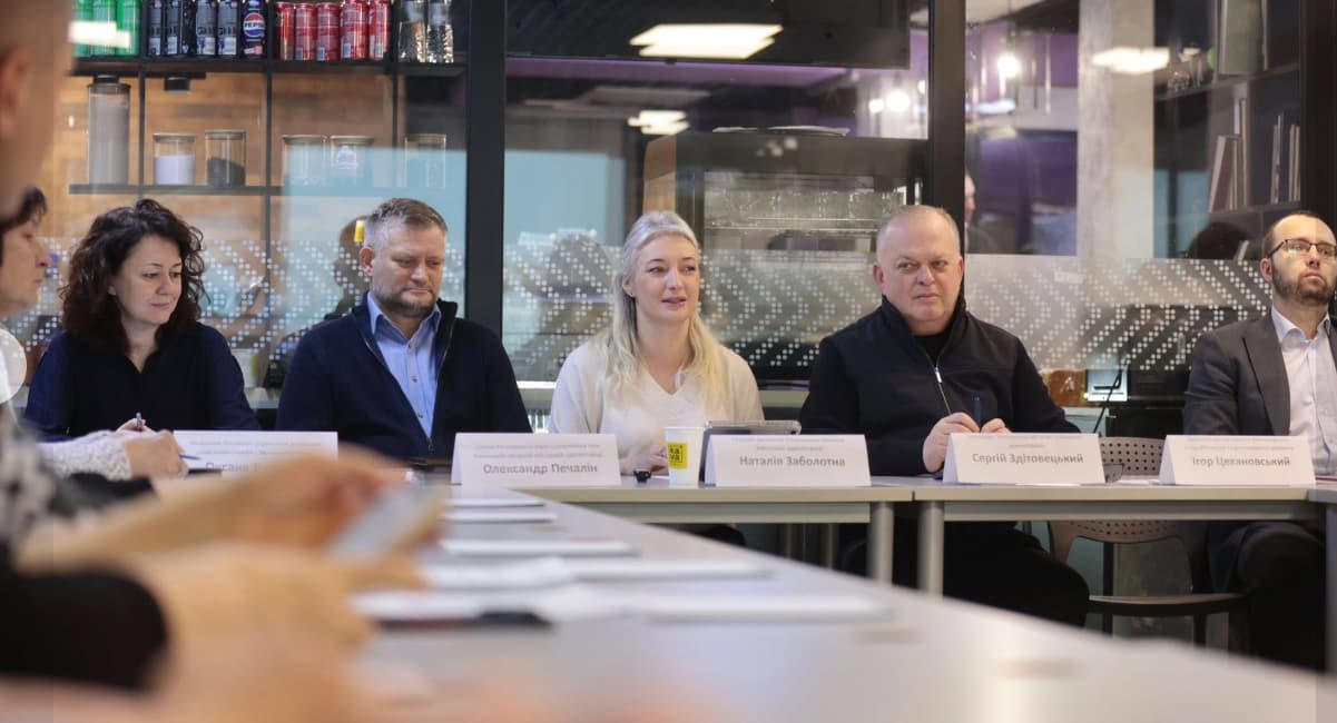 Учасники зустрічі за спільним столом у залі