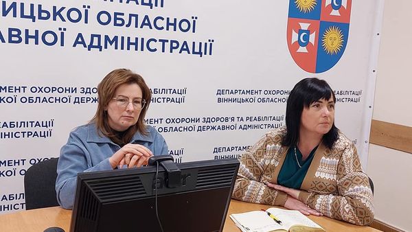Дві жінки сидять за столом.