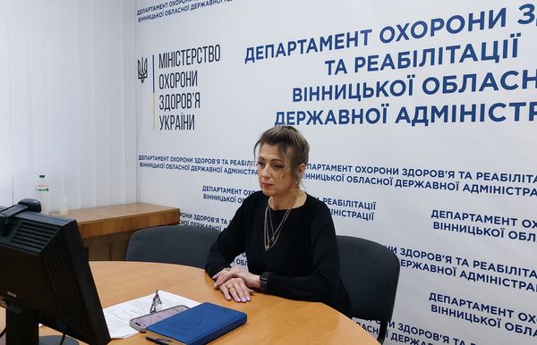 Жінка за столом перед комп'ютером.
