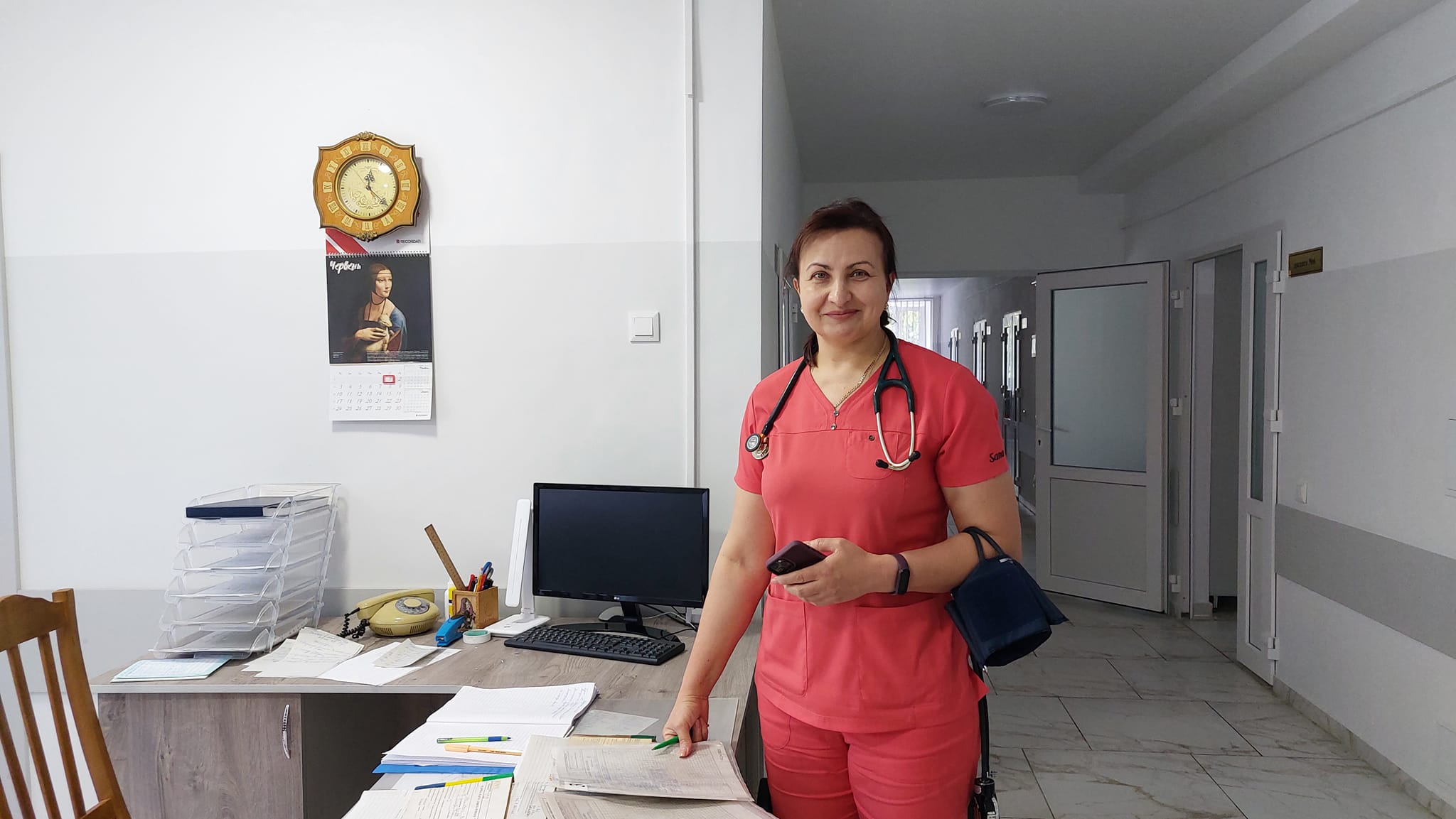 Жінка в медичній формі стоїть у палаті лікарні.