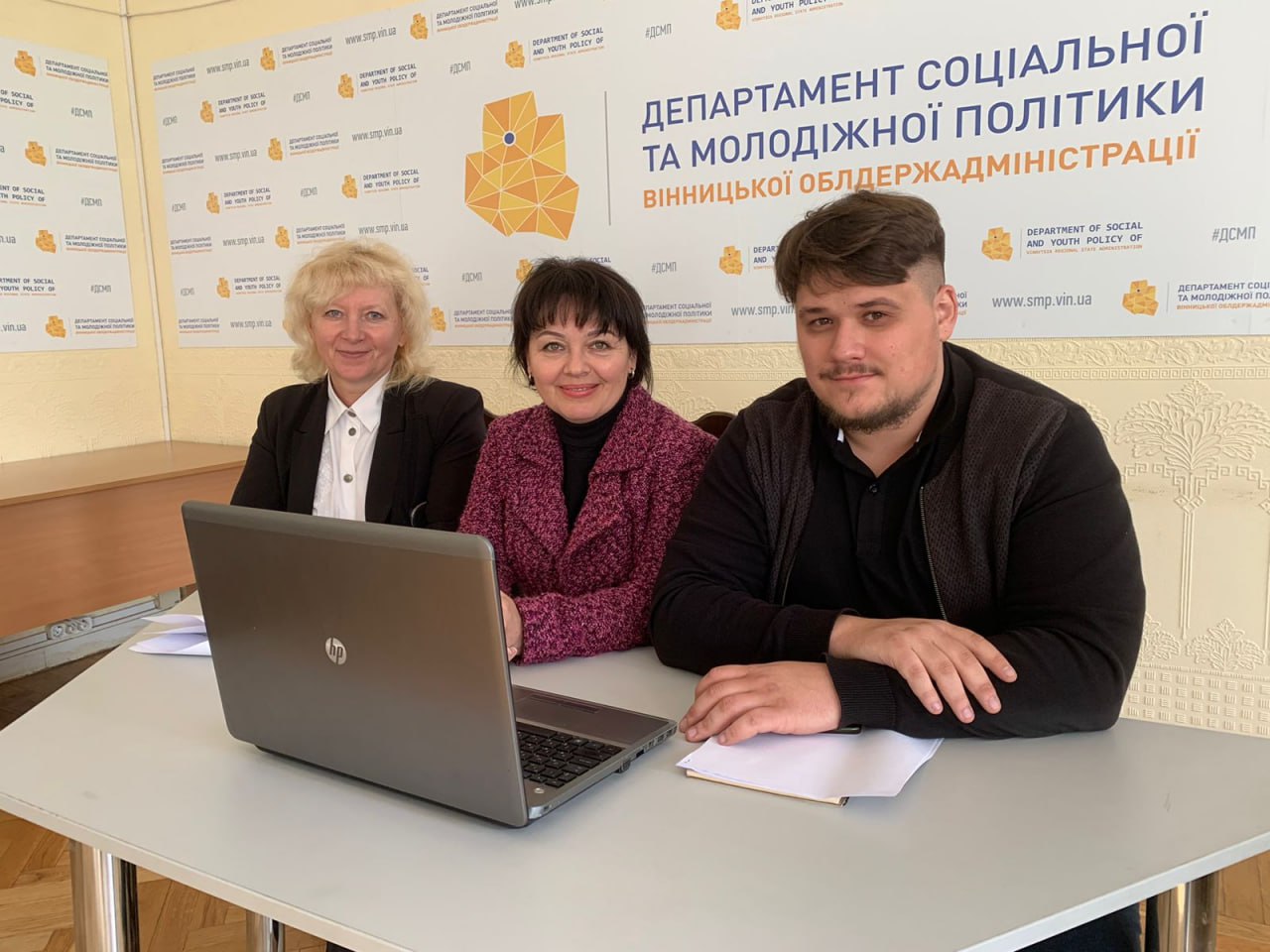 Дві жінки і чоловік біля ноутбука.
