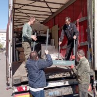 Чоловіки розвантажують гуманітарну допомогу