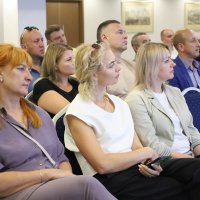 Директор Департаменту Олег Сідоров разом з іншими учасниками сидять в залі і слухають доповідача 