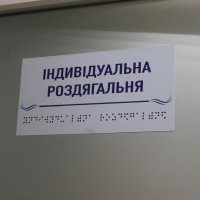 табличка "Індивідуальна роздягальня" написана шрифтом Брайля