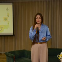 Заступник міністра Мінветеранів стоїть в залі в руці тримає мікрофон