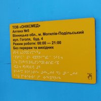 інформаційна табличка написана шрифтом Брайля