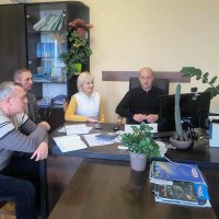 В кабінеті за робочим  столом сидят працівники, перед ними монітор комп'ютера та записники