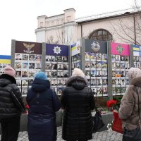 Люди з квітами біля Стіни пам'яті