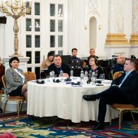 Фото жінок та чоловіків за столом.