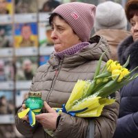 Жінка з квітами біля Стіни пам'яті