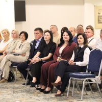 Працівники Департаменту разом з іншими учасниками сидять в залі і слухають доповідача 