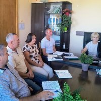 В кабінеті за робочим  столом сидят працівники, перед ними монітор комп'ютера та записники