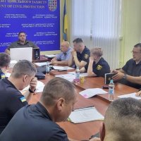 Учасники наради сидять за столом в приміщенні ДЦЗ