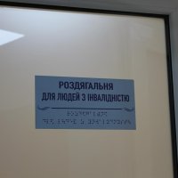 табличка "Роздягальня для людей з інвалідністю" написана шрифтом Брайля